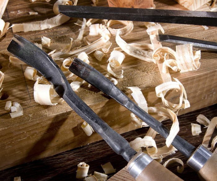 Schnitzeisen auf Holzbrett mit Hobelspänen